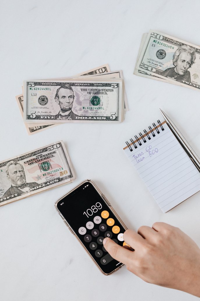 budget calculator with piles of money for bills to deal with debt. Making calculations to answer the question: Should I file for bankruptcy?